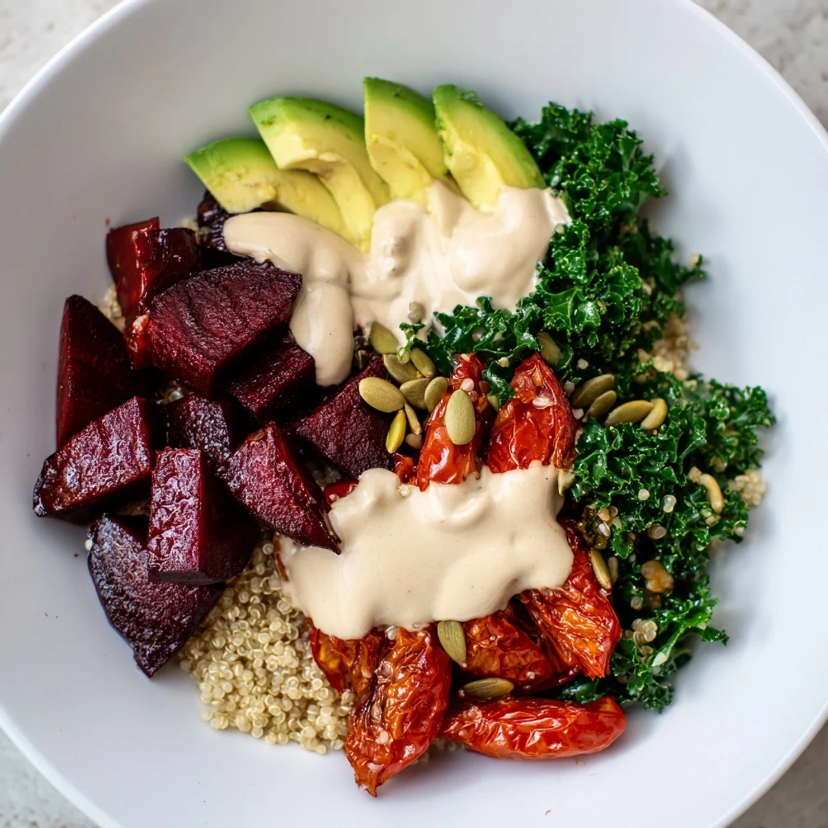 Steaming quinoa, roasted beets, and kale drizzled with tahini in this beautiful Quinoa, Kale & Roasted Beet Bowl.