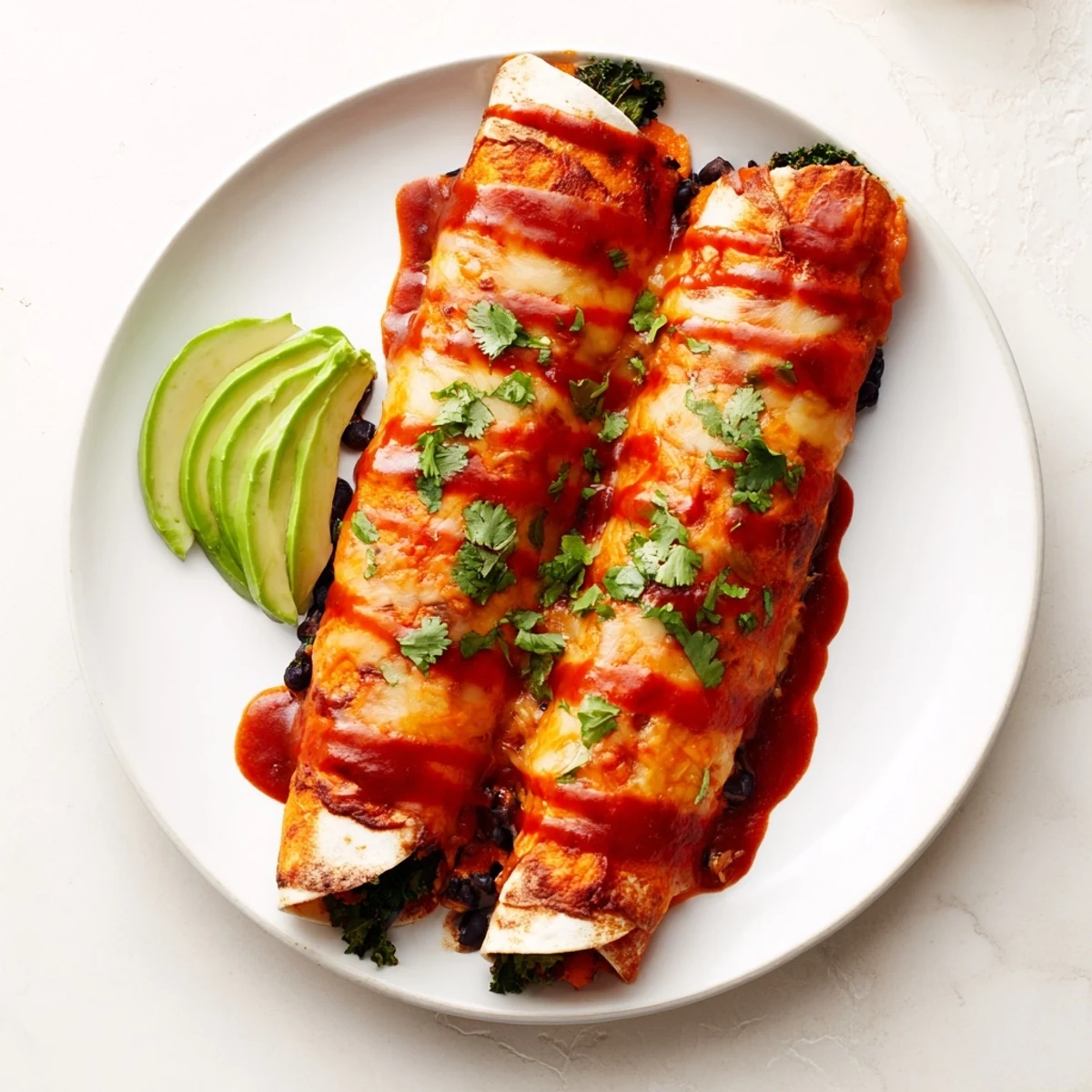 Golden brown One-Pan Sweet Potato, Black Bean & Kale Enchiladas, topped with melted cheese, ready for serving.
