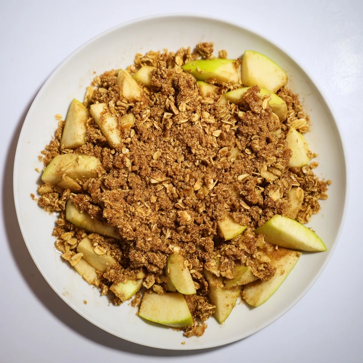 Golden, bubbly Best Apple Crisp with cinnamon-spiced apples, served warm with vanilla ice cream.