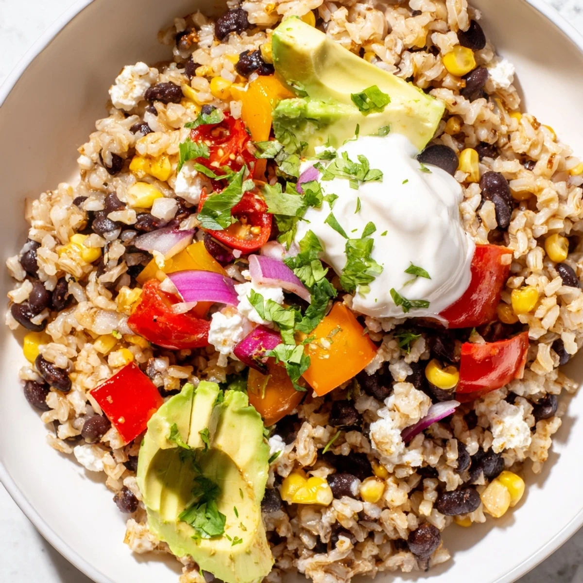 Hearty brown rice burrito bowl with black beans, sweet corn, and avocado, ready for a flavorful, healthy dinner.