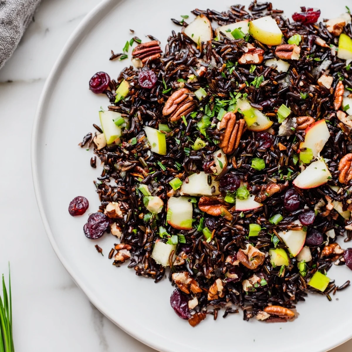 A colorful bowl of Wild Rice Harvest Salad with cranberries and toasted pecans, ready to eat.