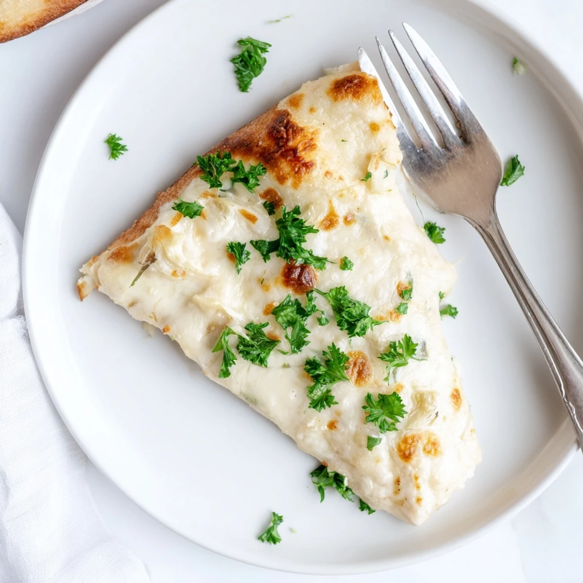 A close-up of Creamy Garlic White Pizza with golden, bubbling mozzarella and a crisp, brushed crust.