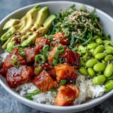 Fresh Salmon Poke Bowl with edamame, avocado, and lime, a beautiful healthy meal concept.