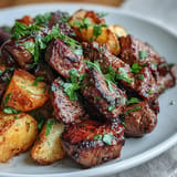 Tender, seared Garlic Butter Steak Bites and Potatoes nestled with fresh parsley.