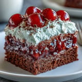 A colorful Cherry Cola Jello Poke Cake, glistening and ready to be served.