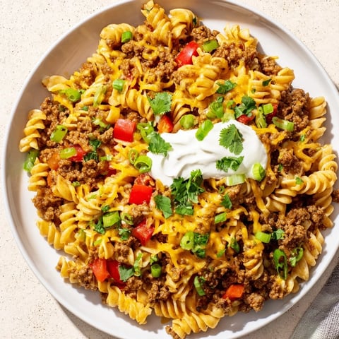 Hot, cheesy Cheesy Taco Pasta Skillet topped with cilantro, perfect for a family dinner.