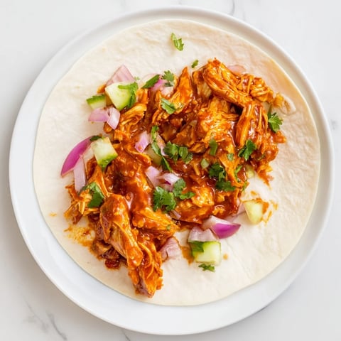 Tantalizing photo of sticky chicken tikka masala tacos served alongside fresh cilantro and lime wedges.