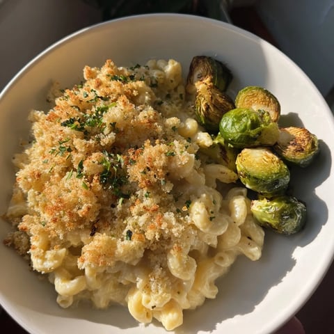 Golden, bubbly Sheet Pan Mac and Cheese with crispy Brussels sprouts, ready to serve with fresh parsley.