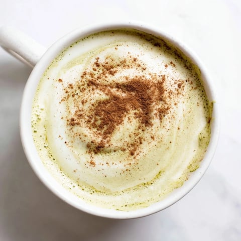 Frothy, vibrant green Cinnamon Maple Oat Milk Matcha Latte, garnished with cinnamon, ready to enjoy.