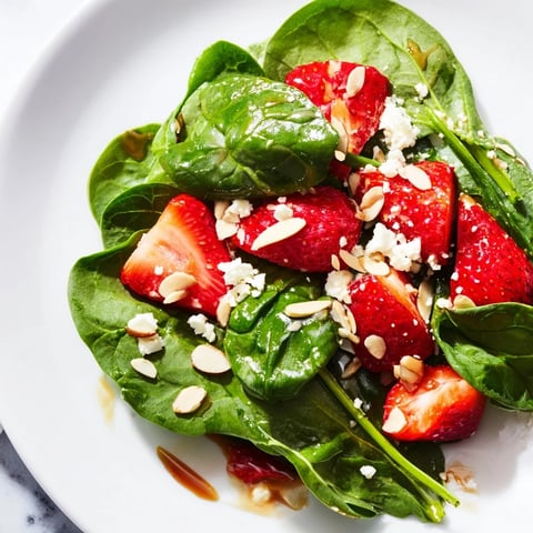 Beautiful Strawberry Spinach Salad with bright red strawberries and crumbled feta cheese.