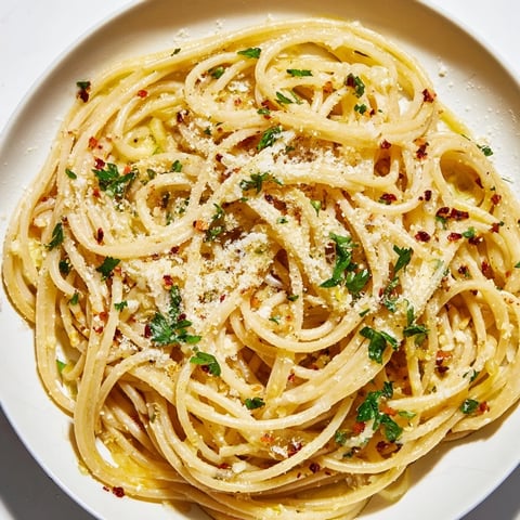 Steaming bowl of Aglio e Olio express pasta, glistening with olive oil and fresh parsley.