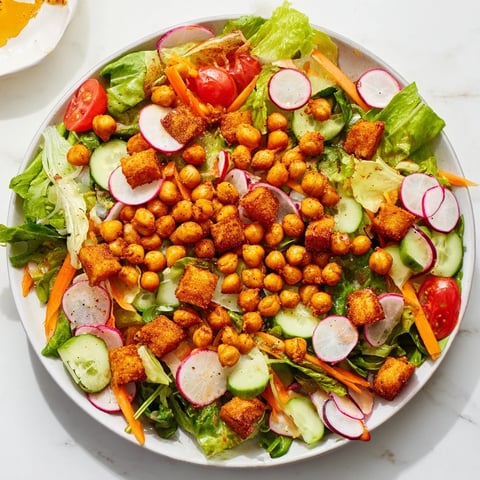 A colorful Mixed Greens Salad with crispy chickpea croutons: a healthy vegan delight.