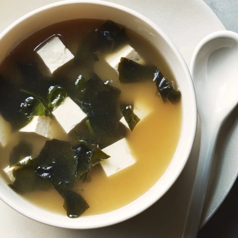 Silken tofu cubes and rehydrated wakame seaweed swim in a warm, golden miso broth, garnished with fresh scallions in this comforting Miso Soup With Tofu.  
