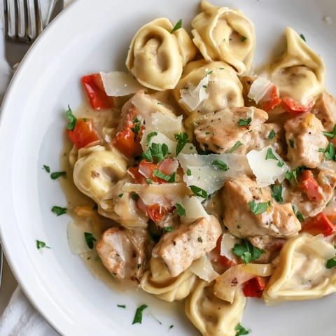 Deliciously garnished Zesty Cajun Garlic Parmesan Chicken Tortellini ready for a flavorful dinner.  