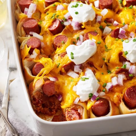 Hearty Chili Dog Casserole baked with gooey cheese and colorful chives on top.  