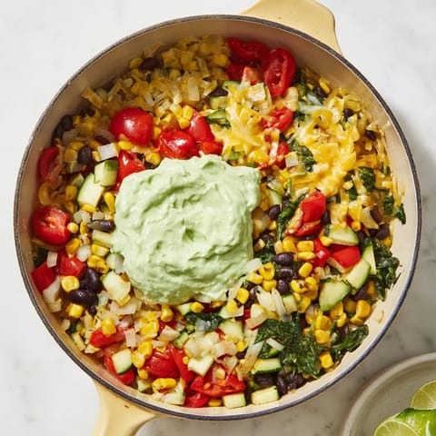 A steaming skillet of veggie-packed taco, spiced perfectly, with cheese, cilantro, and fresh lime wedges.