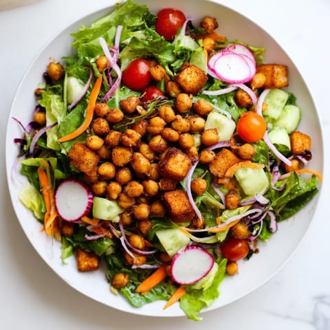 Golden, crunchy chickpea croutons top the fresh Mixed Greens Salad, ready to eat.