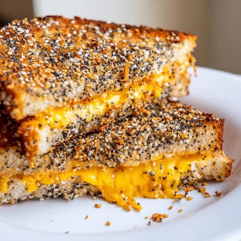 Golden, crispy Everything Bagel Grilled Cheese with a sprinkle of seasoning ready to cut.