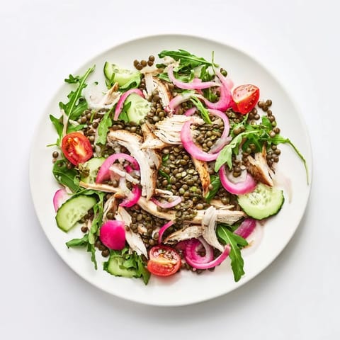 Plated Lentil & Chicken Spring Salad topped with tangy pickled onions, cherry tomatoes, and cucumber for a refreshing, high-protein lunch.  