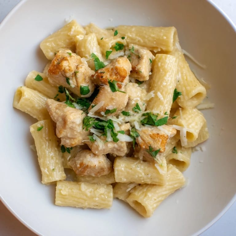 A close-up of Creamy Garlic Parmesan Chicken Rigatoni, showing the bubbly, cheesy sauce and pasta.