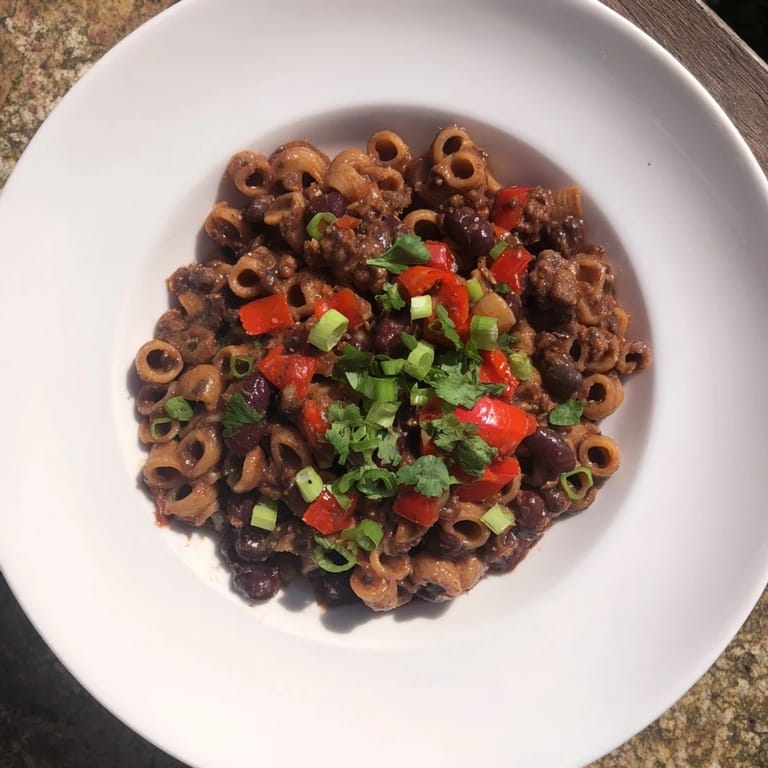 Rich, dark chili with ditalini pasta, featuring melted chocolate and robust spices for a flavorful main course.