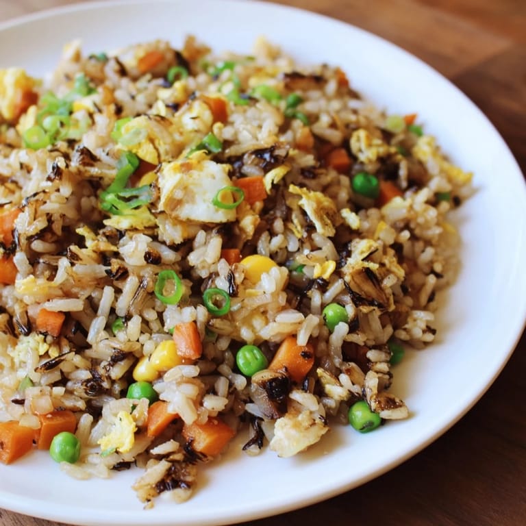 A delicious bowl of Black Garlic Fried Rice, served hot, glistening with sesame oil.