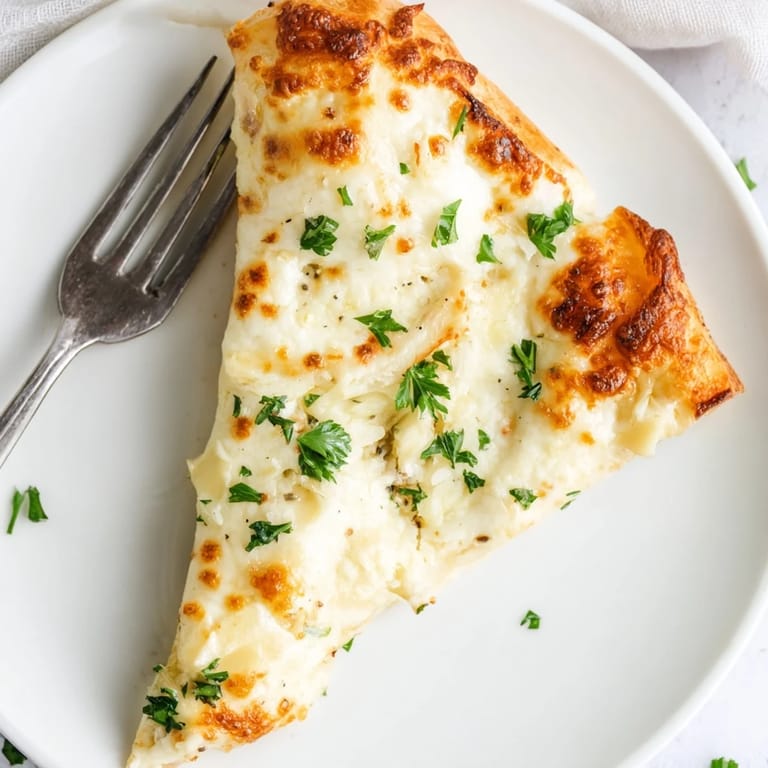 A bubbling Creamy Garlic White pizza fresh from the oven, showcasing its luscious garlic cream sauce.