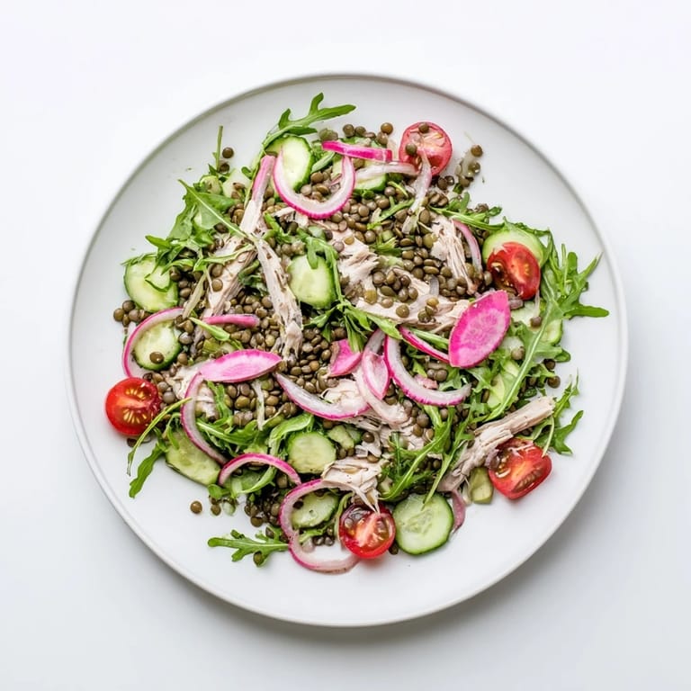 Freshly tossed Lentil & Chicken Spring Salad featuring lentils, arugula, and shredded chicken drizzled with homemade Dijon vinaigrette.