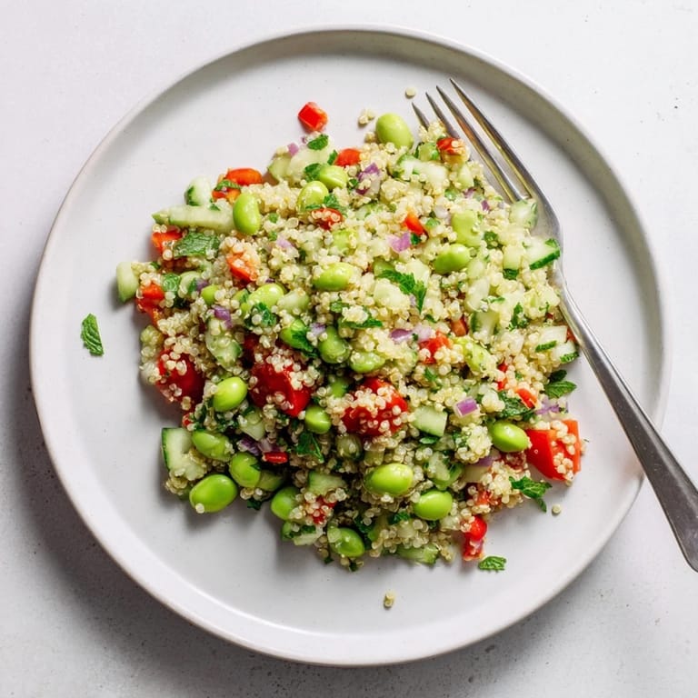 Hearty Edamame and Quinoa Salad served chilled, featuring crisp cucumber and red bell pepper in a zesty lemon dressing.