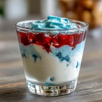 Red, White, and Blue Layered Jello Cups with vibrant stripes, perfect for patriotic celebrations and summer parties.  