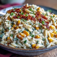 Creamy Corn Orzo topped with fresh chives, a comforting vegetarian side dish.
